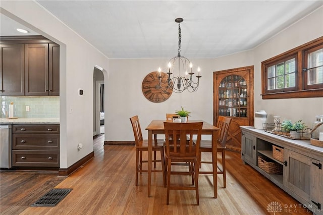439 Monteray Ave, Oakwood, OH 45419 - dining area with arched walkways, a chandelier, and wood finished floors