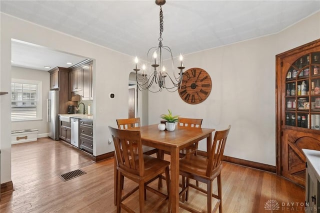 439 Monteray Ave, Oakwood, OH 45419 - dining area with a chandelier, wood finished floors, and arched walkways
