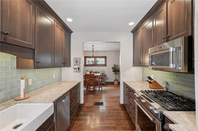439 Monteray Ave, Oakwood, OH 45419 - kitchen with stainless steel appliances, dark wood finished floors, backsplash, a chandelier, and light stone countertops