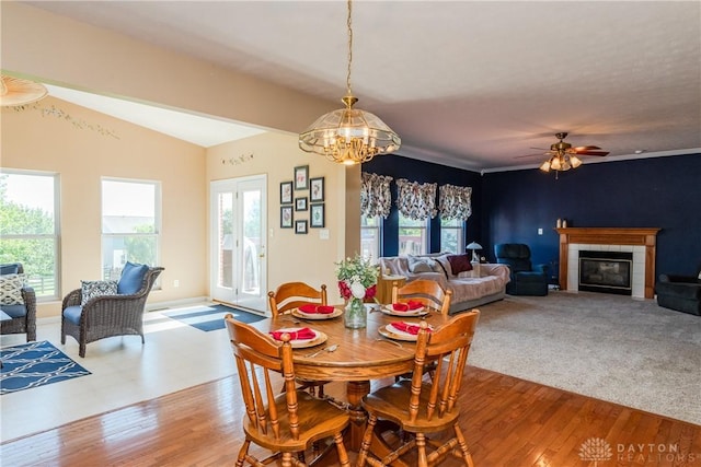 24 Dinsley Pl, Springboro, OH 45066 - dining space featuring a chandelier, light wood-style floors, a tile fireplace, lofted ceiling, and a ceiling fan