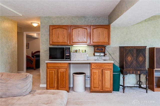 24 Dinsley Pl, Springboro, OH 45066 - kitchen with black microwave, brown cabinets, light countertops, and light colored carpet