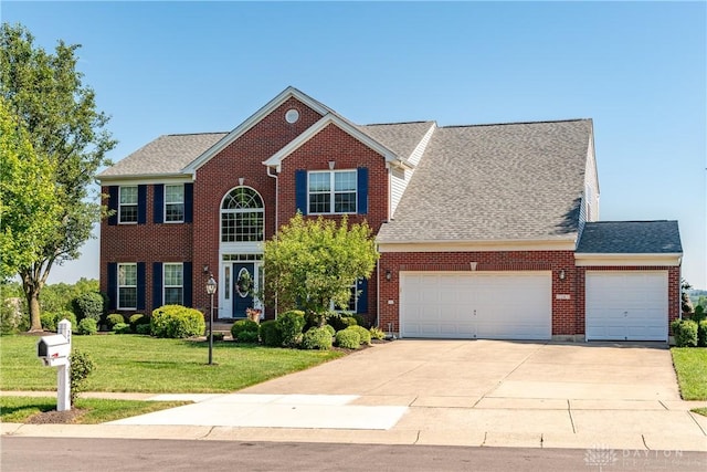 24 Dinsley Pl, Springboro, OH 45066 - colonial-style house featuring a garage, a front lawn, driveway, brick siding, and a shingled roof