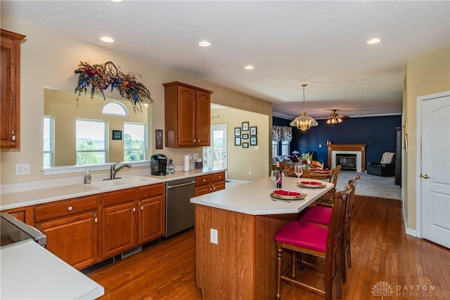 24 Dinsley Pl, Springboro, OH 45066 - kitchen with stainless steel dishwasher, a kitchen island, open floor plan, a glass covered fireplace, and dark wood-type flooring
