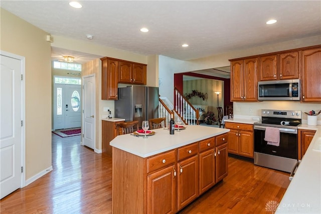 24 Dinsley Pl, Springboro, OH 45066 - kitchen featuring stainless steel appliances, wood finished floors, light countertops, a kitchen island, and recessed lighting