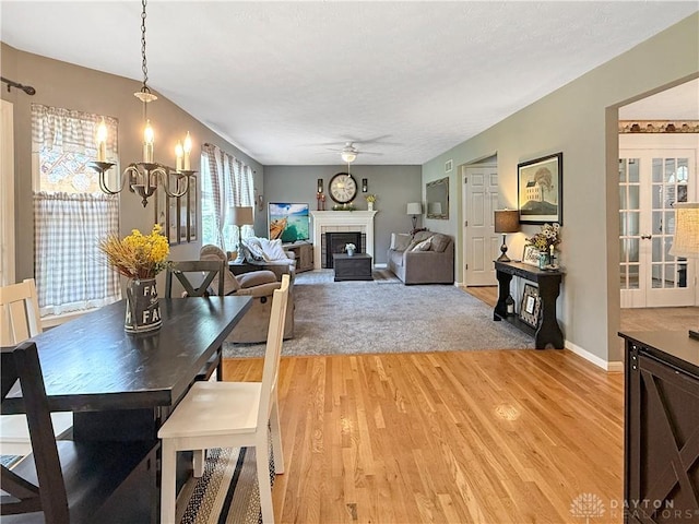1207 Durbin Ter, Maineville, OH 45039 - dining room featuring a ceiling fan, a chandelier, light wood-style floors, and a fireplace