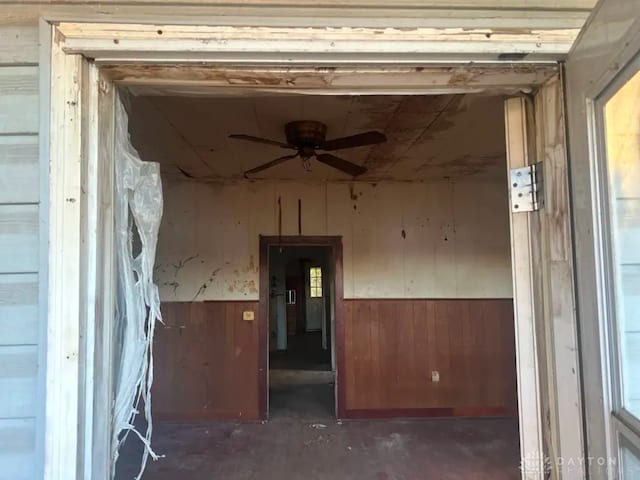 293 S Miami Ave, Xenia, OH 45385 - spare room featuring ceiling fan, concrete floors, wood walls, and a wainscoted wall