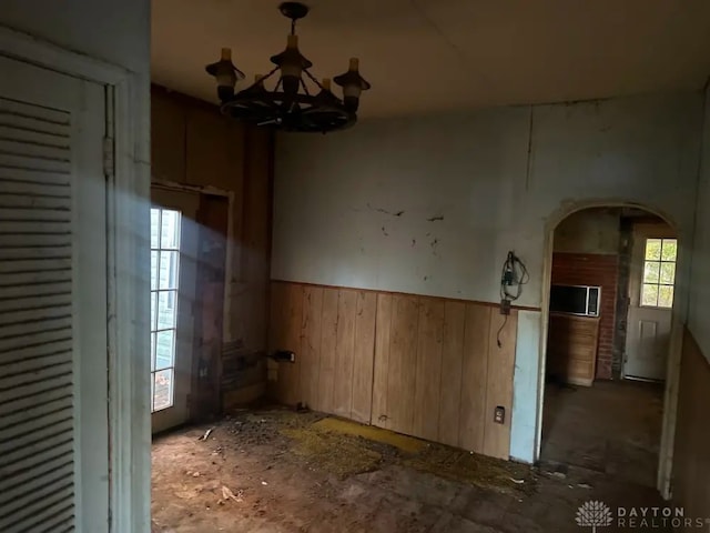 293 S Miami Ave, Xenia, OH 45385 - empty room with a chandelier, arched walkways, wainscoting, and wooden walls