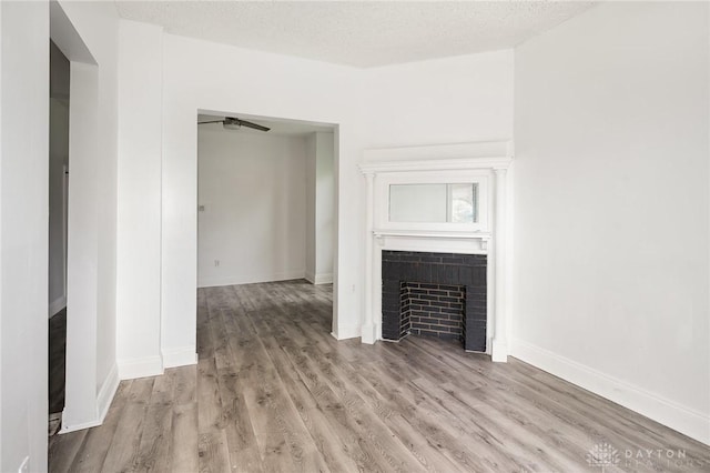 36 Leaman St, Xenia, OH 45385 - unfurnished living room featuring a fireplace, light wood-type flooring, and a textured ceiling