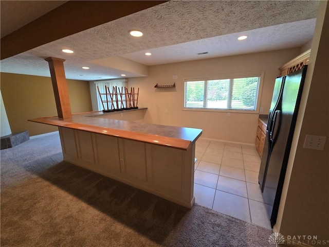 1962 Fountain View Dr, Dayton, OH 45414 - kitchen with a textured ceiling, freestanding refrigerator, light carpet, recessed lighting, and a peninsula