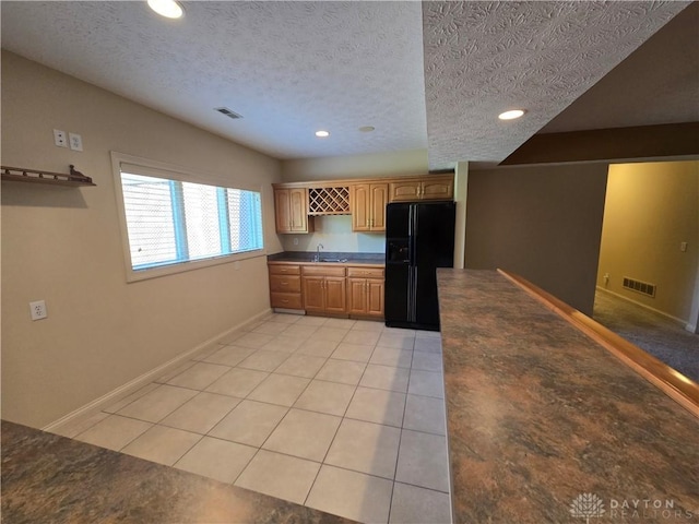 1962 Fountain View Dr, Dayton, OH 45414 - kitchen featuring black fridge with ice dispenser, recessed lighting, a textured ceiling, dark countertops, and light tile patterned floors