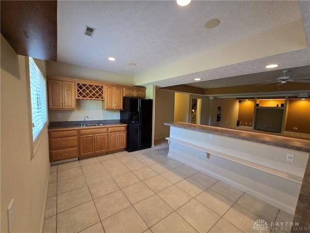 1962 Fountain View Dr, Dayton, OH 45414 - kitchen with black fridge, light tile patterned floors, a textured ceiling, recessed lighting, and dark countertops