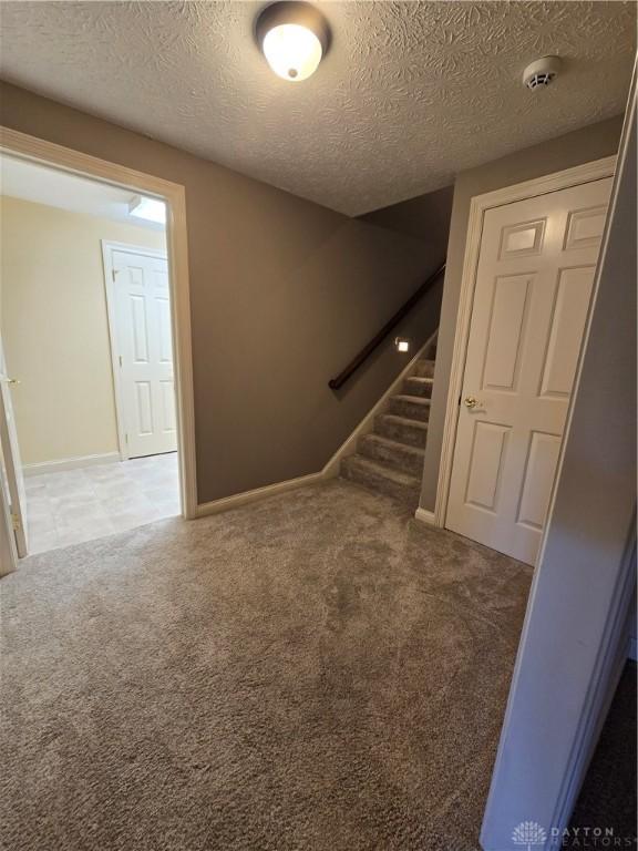 1962 Fountain View Dr, Dayton, OH 45414 - stairs featuring carpet floors and a textured ceiling