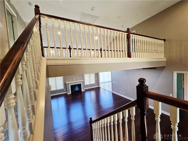 1962 Fountain View Dr, Dayton, OH 45414 - staircase featuring wood finished floors, a glass covered fireplace, and a high ceiling