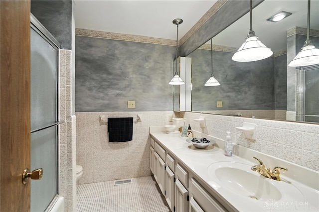 328 Shadywood Dr, Clayton, OH 45415 - bathroom featuring double vanity, tile patterned flooring, an enclosed shower, and tile walls