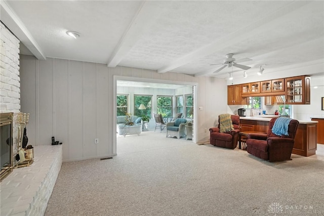 328 Shadywood Dr, Clayton, OH 45415 - living room with light colored carpet, beamed ceiling, ceiling fan, and a fireplace