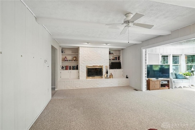 328 Shadywood Dr, Clayton, OH 45415 - unfurnished living room featuring a textured ceiling, carpet floors, a ceiling fan, a brick fireplace, and built in features
