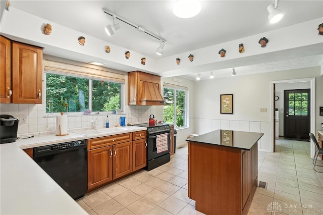 328 Shadywood Dr, Clayton, OH 45415 - kitchen with black appliances, track lighting, light tile patterned floors, a kitchen island, and wainscoting