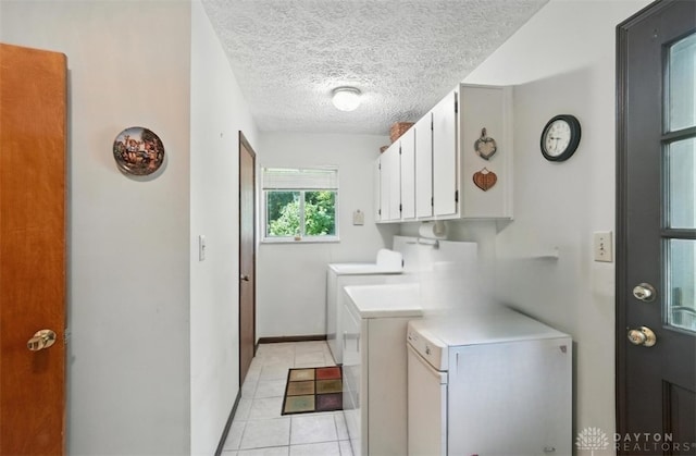 328 Shadywood Dr, Clayton, OH 45415 - washroom featuring separate washer and dryer, a textured ceiling, light tile patterned floors, and cabinet space