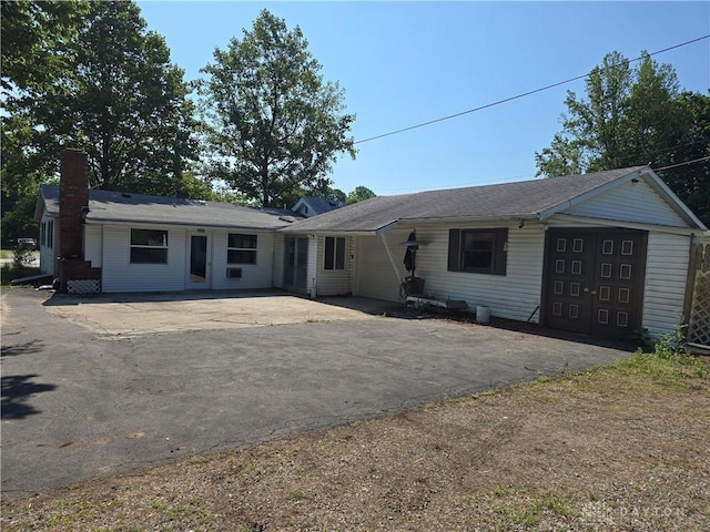 1119 N Maple St, Eaton, OH 45320 - single story home with a chimney, asphalt driveway, and a garage