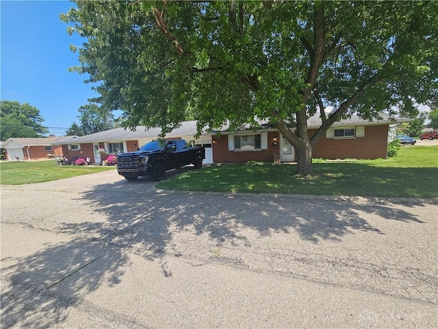 103 N Taylor St Unit 101, Farmersville, OH 45325 - ranch-style home with driveway, a front lawn, brick siding, and a garage