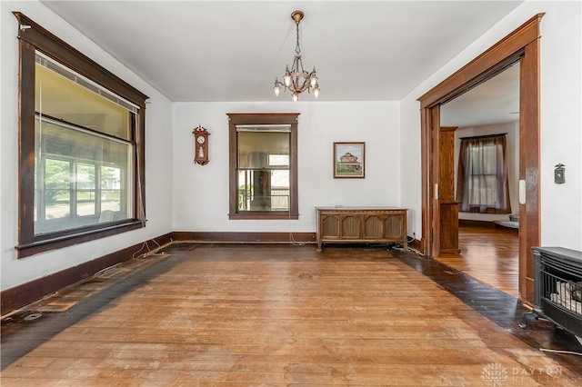 307 E Cherry St, New Paris, OH 45347 - unfurnished dining area featuring hardwood / wood-style flooring, plenty of natural light, a chandelier, and a wood stove