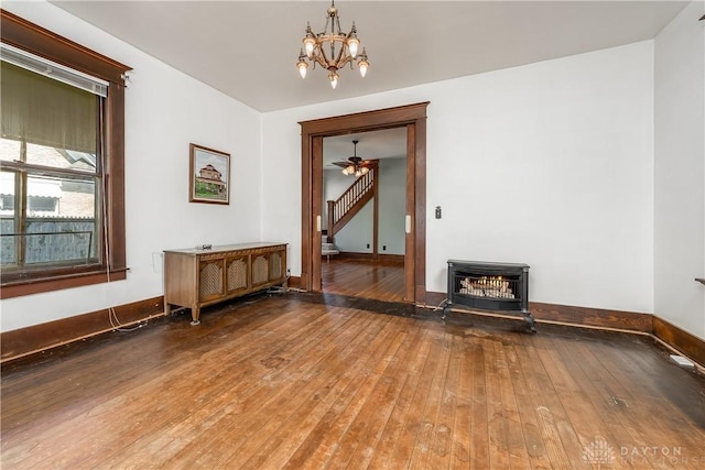 307 E Cherry St, New Paris, OH 45347 - unfurnished room with a wood stove, wood-type flooring, a chandelier, and ceiling fan