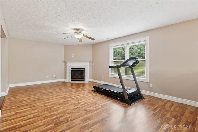 4307 Dobbin Cir, Dayton, OH 45424 - exercise area with ceiling fan, light wood-style floors, a fireplace, and a textured ceiling