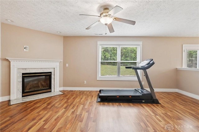 4307 Dobbin Cir, Dayton, OH 45424 - exercise room with wood finished floors, healthy amount of natural light, a textured ceiling, a ceiling fan, and a premium fireplace