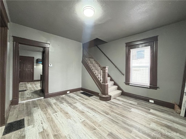 1239 Sliker Ave, Cincinnati, OH 45205 - below grade area with wood finished floors, stairs, and a textured ceiling