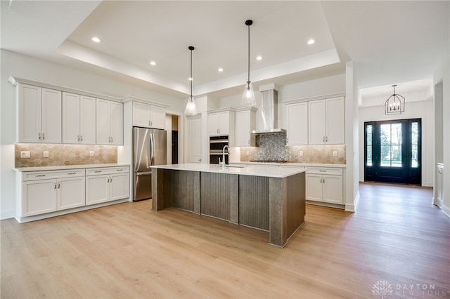 9508 Magnolia Ct, Washington Twp, OH 45458 - kitchen with stainless steel fridge, wall chimney range hood, a tray ceiling, light wood finished floors, and recessed lighting