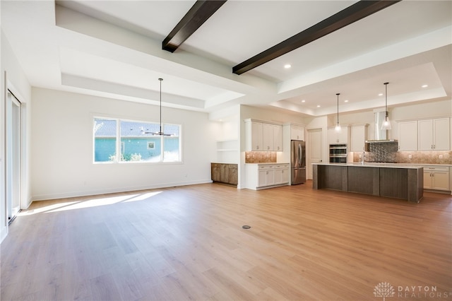 9508 Magnolia Ct, Washington Twp, OH 45458 - unfurnished living room featuring a tray ceiling, light wood-style floors, recessed lighting, and a chandelier
