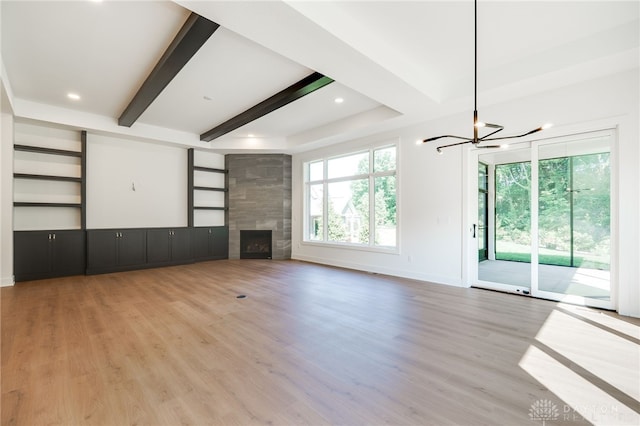 9508 Magnolia Ct, Washington Twp, OH 45458 - unfurnished living room with a chandelier, a high end fireplace, beam ceiling, wood finished floors, and built in shelves