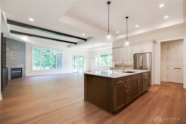 9508 Magnolia Ct, Washington Twp, OH 45458 - kitchen with open floor plan, dark brown cabinets, stainless steel appliances, light wood-style floors, and light countertops