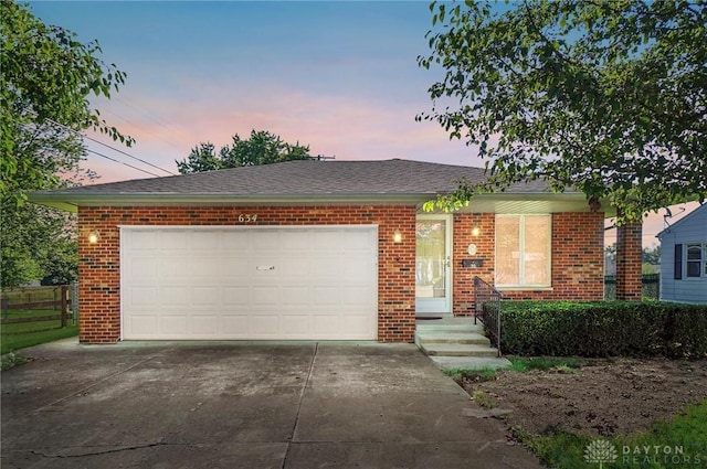 634 S Main, West Milton, OH 45383 - view of front facade featuring brick siding, driveway, and a garage