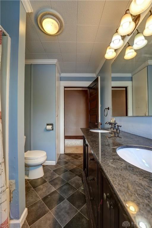 513 S High St, Arcanum, OH 45304 - bathroom featuring double vanity, crown molding, and tile patterned flooring