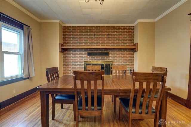 513 S High St, Arcanum, OH 45304 - dining area with wood finished floors, crown molding, and a fireplace