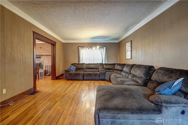 513 S High St, Arcanum, OH 45304 - living area featuring hardwood / wood-style flooring, a textured ceiling, wood walls, and crown molding