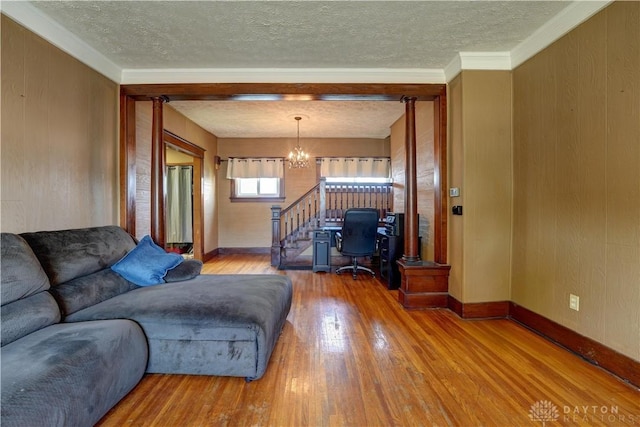 513 S High St, Arcanum, OH 45304 - living room featuring a chandelier, a textured ceiling, stairway, and hardwood / wood-style floors