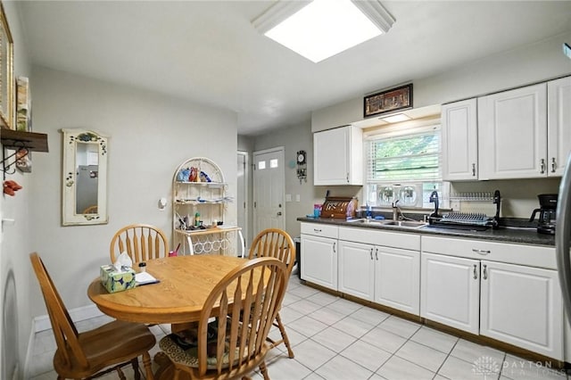 4513 Hannah Dr, Middletown, OH 45044 - kitchen with light tile patterned floors, white cabinetry, and dark countertops