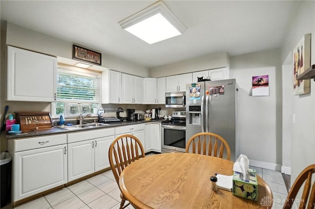 4513 Hannah Dr, Middletown, OH 45044 - kitchen with stainless steel appliances, light tile patterned floors, white cabinetry, and dark countertops