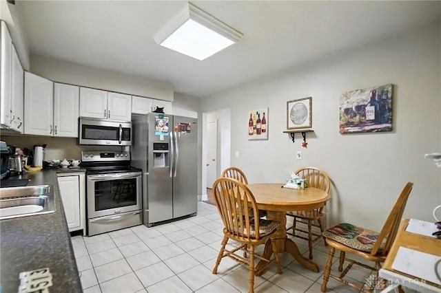 4513 Hannah Dr, Middletown, OH 45044 - kitchen featuring appliances with stainless steel finishes, dark countertops, white cabinetry, and light tile patterned flooring