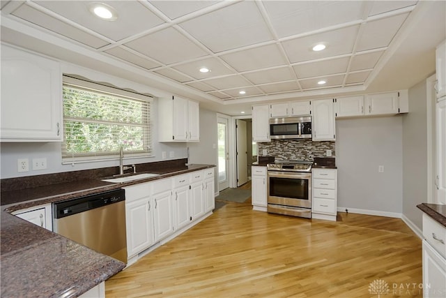 5975 Oakridge Dr, Hamilton, OH 45011 - kitchen featuring appliances with stainless steel finishes, dark countertops, white cabinets, light wood-style floors, and recessed lighting