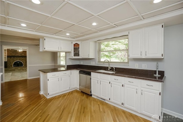 5975 Oakridge Dr, Hamilton, OH 45011 - kitchen with stainless steel dishwasher, light wood-style flooring, a peninsula, dark countertops, and white cabinets