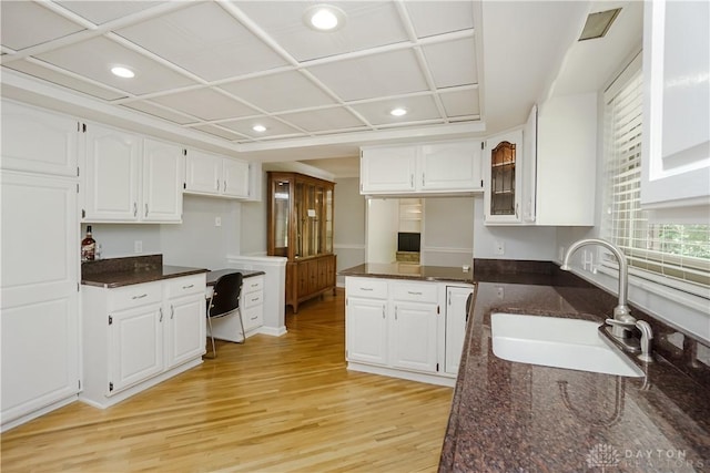 5975 Oakridge Dr, Hamilton, OH 45011 - kitchen with light wood-style floors, white cabinets, dark stone counters, glass insert cabinets, and recessed lighting