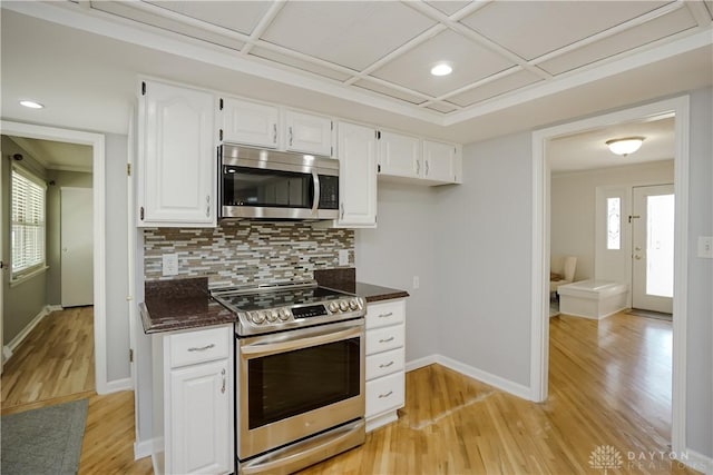 5975 Oakridge Dr, Hamilton, OH 45011 - kitchen with stainless steel appliances, light wood finished floors, decorative backsplash, white cabinetry, and recessed lighting