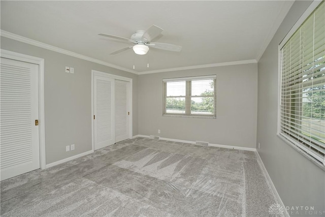 5975 Oakridge Dr, Hamilton, OH 45011 - unfurnished bedroom featuring crown molding, carpet flooring, two closets, and a ceiling fan