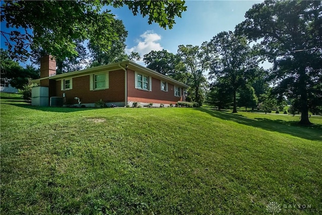 5975 Oakridge Dr, Hamilton, OH 45011 - view of side of property featuring brick siding, a chimney, and a yard