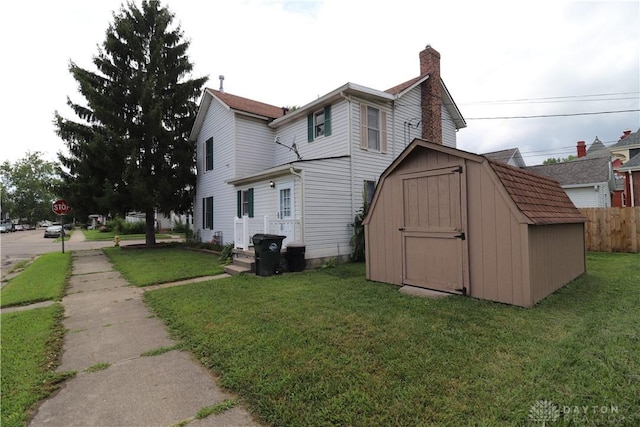 230 S 5th St, Miamisburg, OH 45342 - view of side of home featuring a storage shed, a lawn, and a chimney