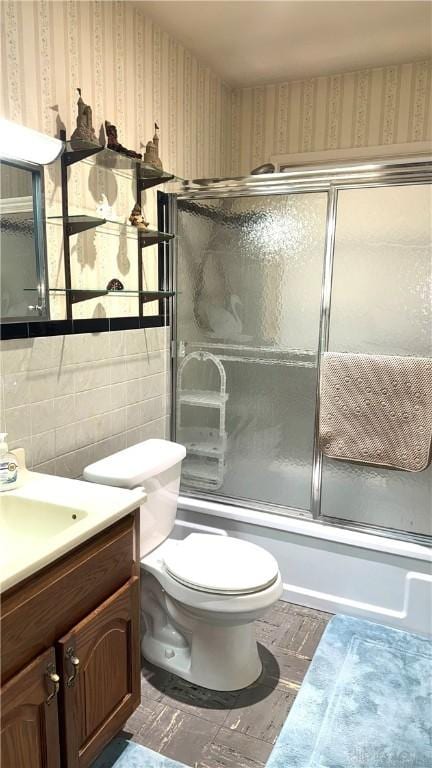 120 W Doris Dr, Fairborn, OH 45324 - bathroom featuring vanity, combined bath / shower with glass door, wallpapered walls, and tile walls