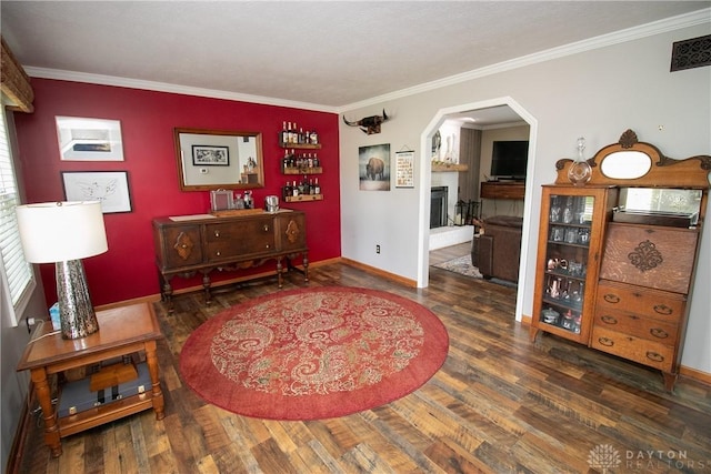 6377 Holloway Dr, Liberty Twp, OH 45044 - living area with ornamental molding, arched walkways, a fireplace with raised hearth, and wood finished floors